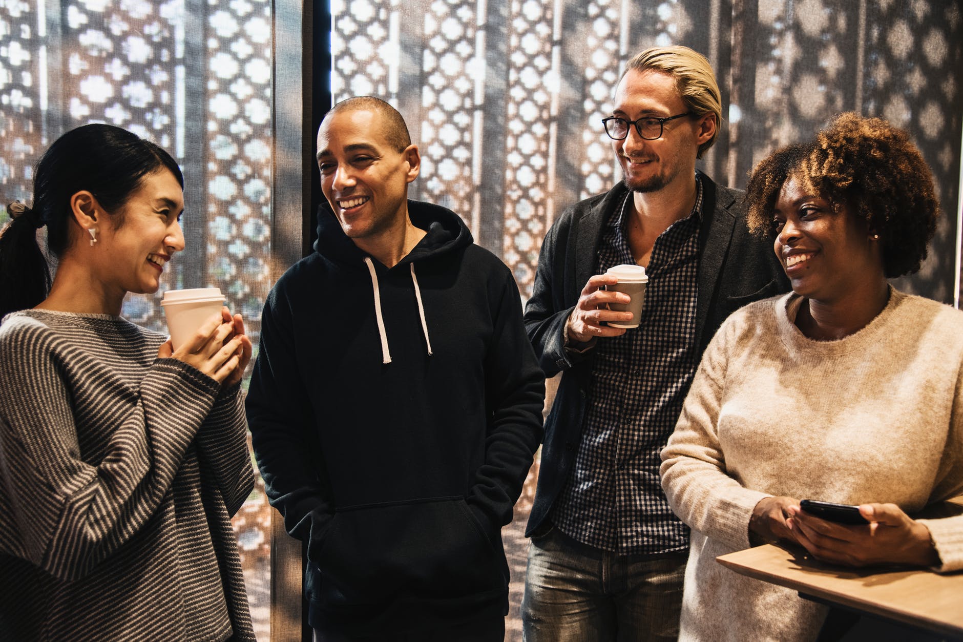 Four people standing and socialising. 
